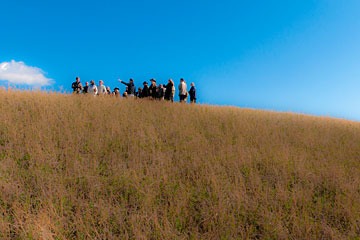 group of people standing on grass-covered hillside at La Bandita in Tuscany
