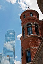 Richardsonian Romanesque red stone building in foreground with glass skyscraper in background