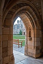 view through stone archway to bench looking into academic courtyard at Yale University