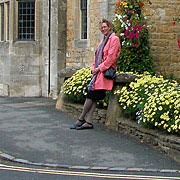 Wanda Mouzon resting against round-top bollard on Bourton-On-The-Water in England