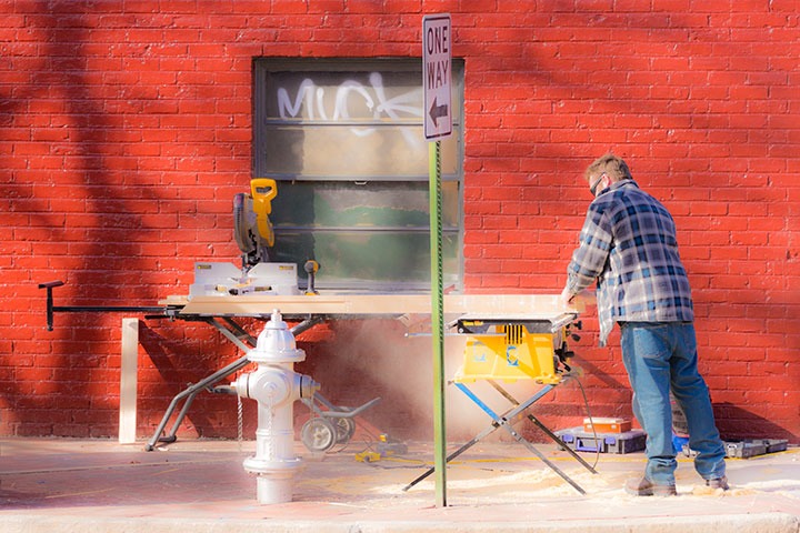 carpenter cutting on the sidewalk in Richmond’s Shockoe Bottom neighborhood