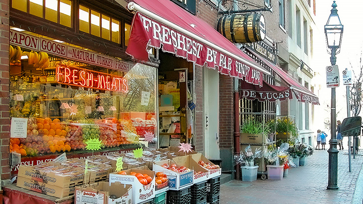 market on Boston's Beacon Street with produce under a maroon awning