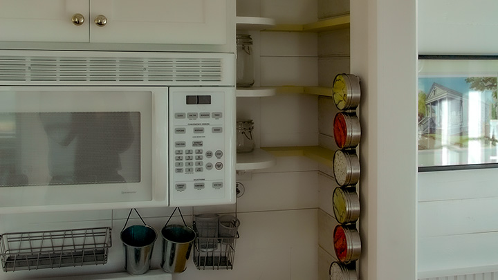 shelf-wall in kitchen of Katrina Cottage VIII are boarded on one side only so the interior can be used for storage