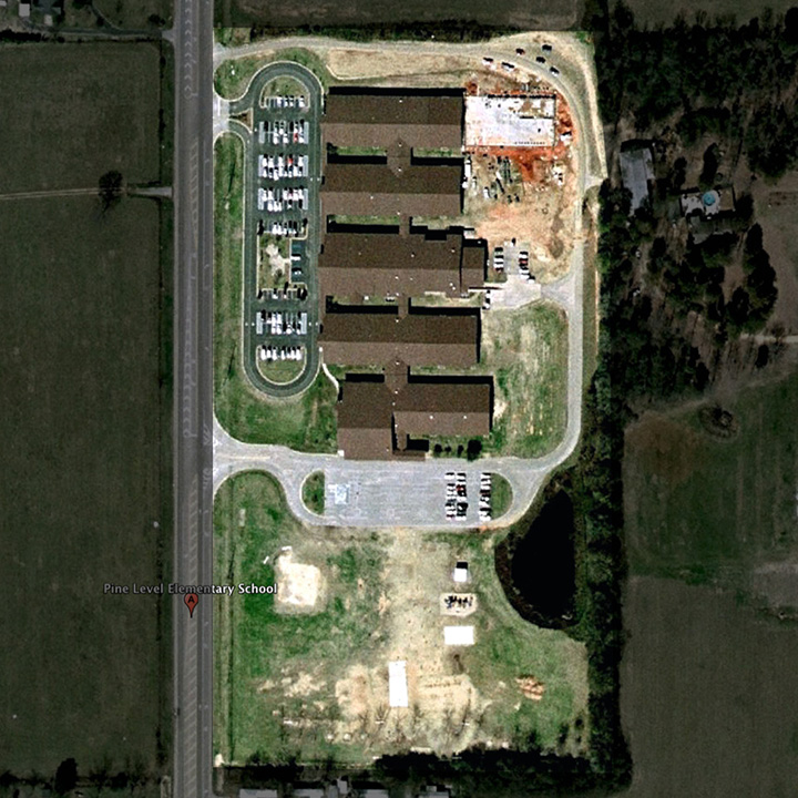 Alabama school satellite photo showing acres of stack lanes for picking up kids at highway schools