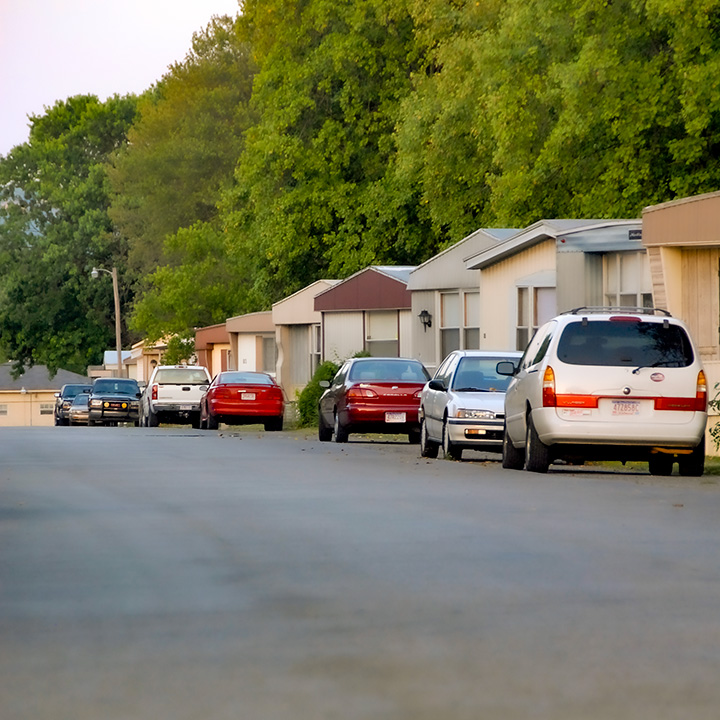 cars lined up beside mobile homes