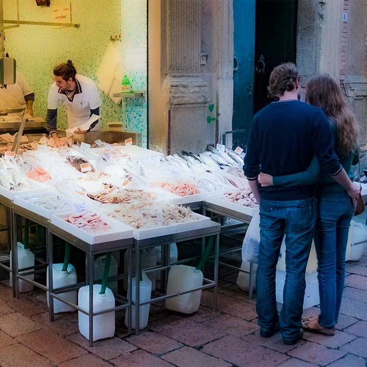 couple shopping at fish market in Bologna, Italy