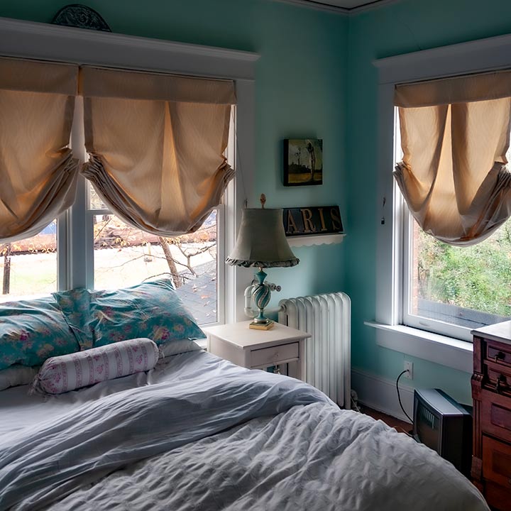 tiny bedroom with windows on two sides