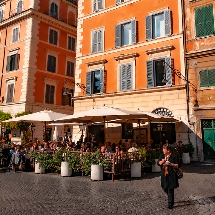 Rome sidewalk cafe at the foot of 4-story stucco building