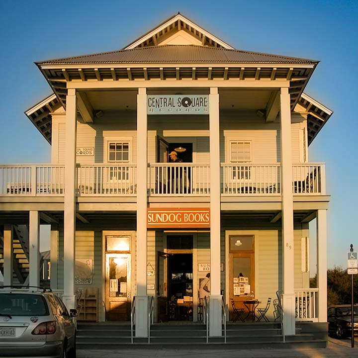 the Sundog Books building on Seaside, Florida’s Central Square glows in late afternoon sunlight against a clear blue sky