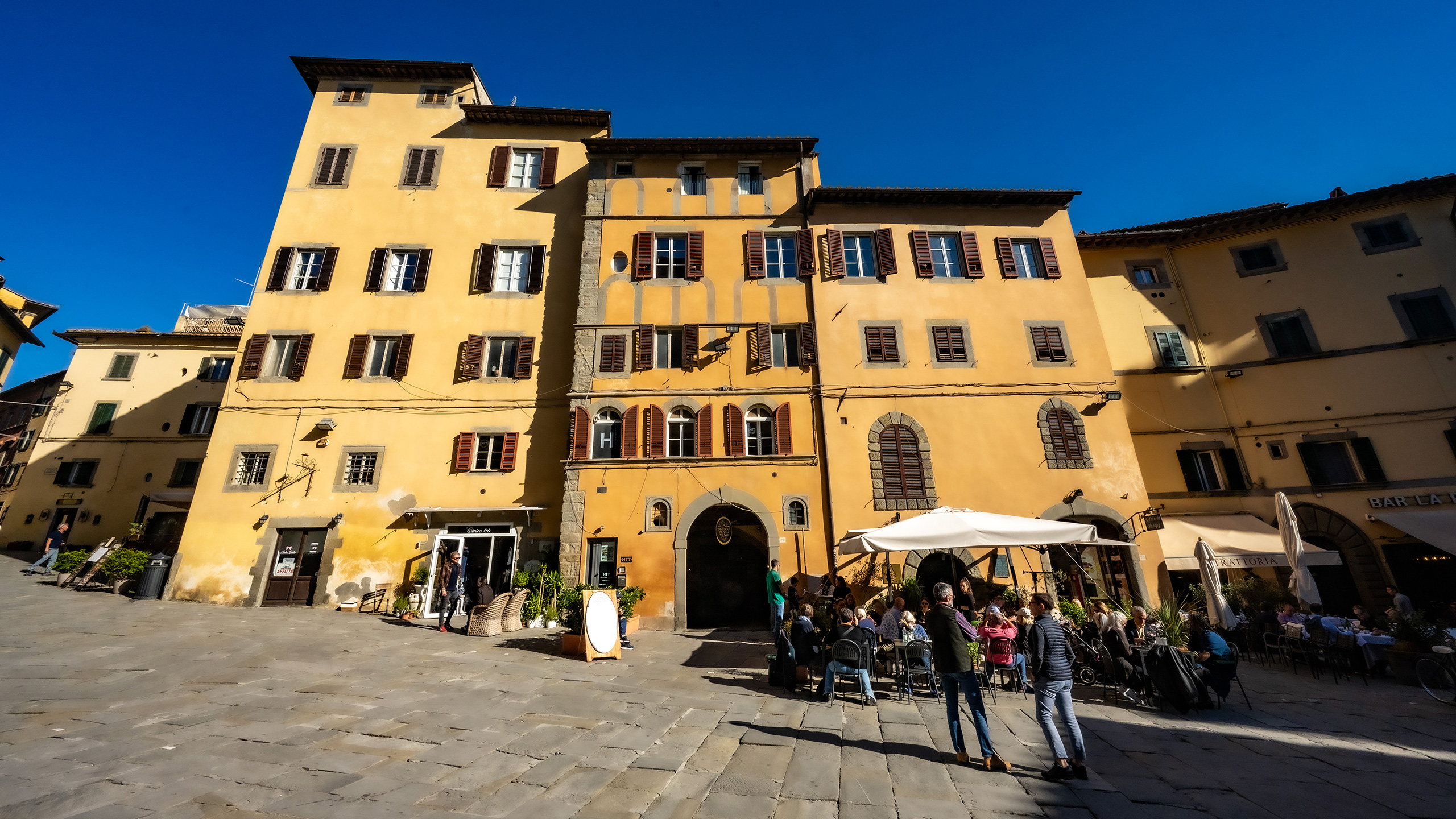 narrow-front shops fronting piazza in Cortona, Italy