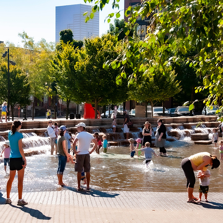 parents and their children playing in Portland splash fountain that's an integral part of Pearl District urbanism