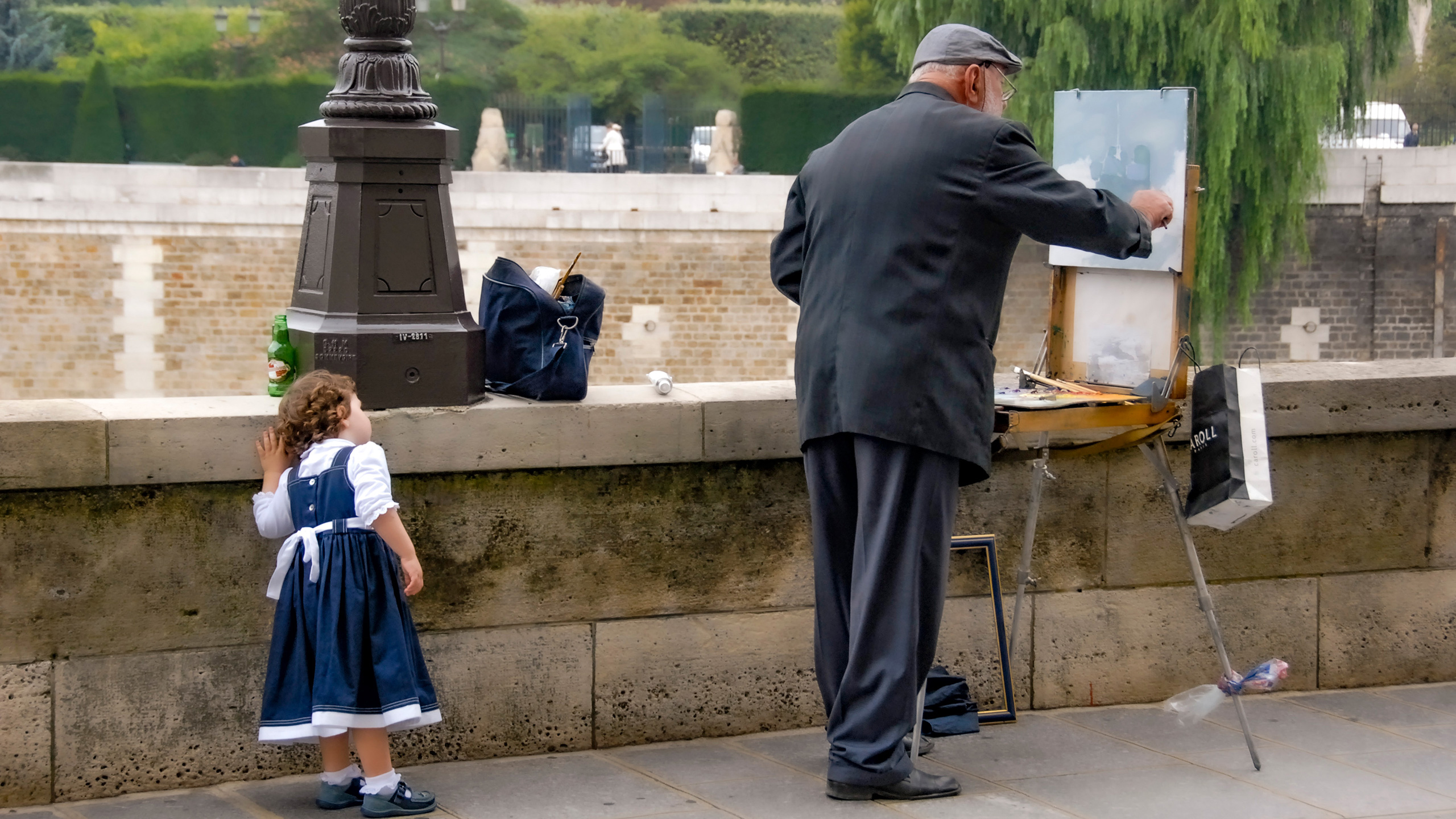 young girl watching old man paint on Paris sidewalk