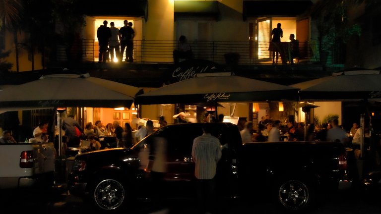 Good urbanism always has strong Walk Appeal, which has a secret property: excellent traffic calming. Stuck in traffic on a boring street, people get angry. But with an interesting scene like this, the guy in the truck just creeping by is having a happy conversation. &copy;2008 Stephen A. Mouzon