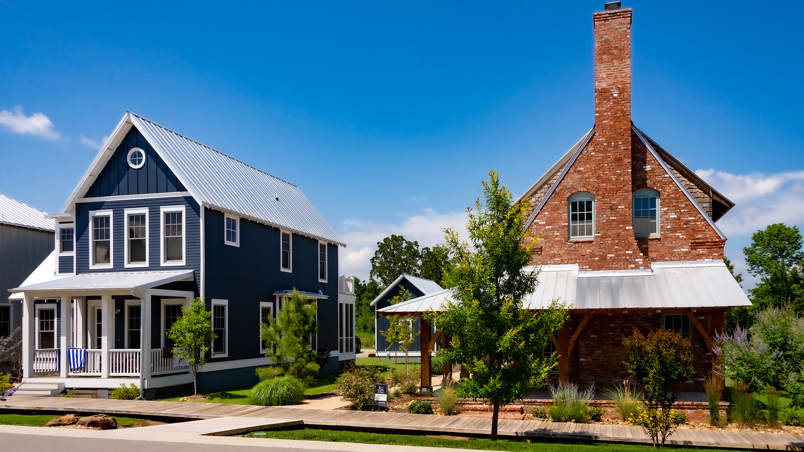 two houses in Carlton Landing, Oklahoma speaking two decidedly different architectural languages