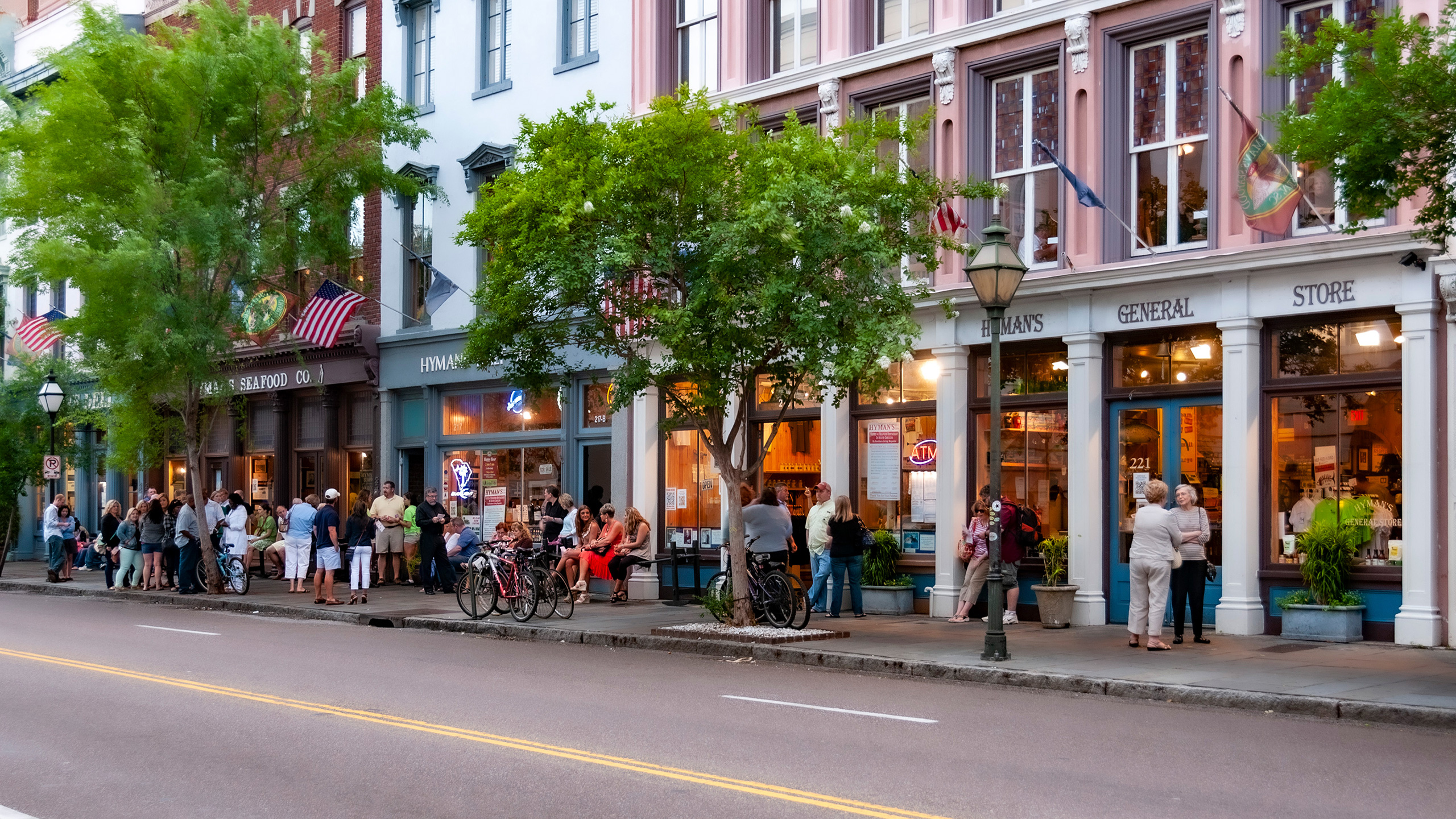 people thronging a sidewalk on Meeting Street in Charleston, South Carolina